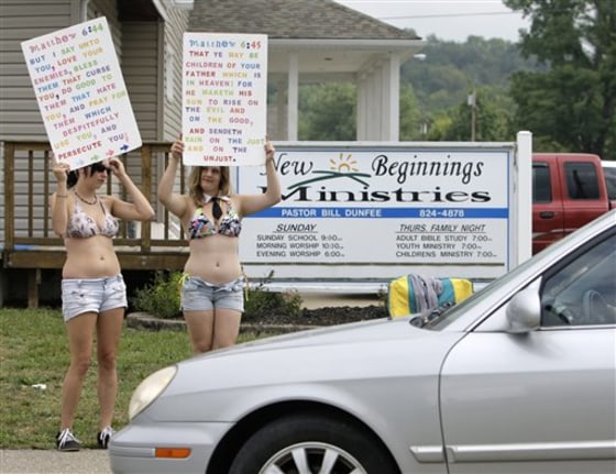Supporters of The Fox Hole strip club, Elizabeth Smith, left, and Brittany Johnson, both of Mansfield, protest against New Beginnings Ministries Church in Warsaw, Ohio, on Sunday.